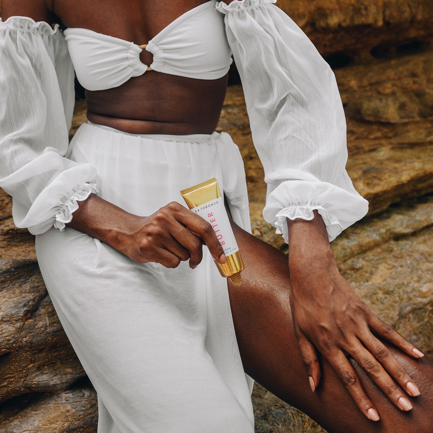 Black woman rubbing African Beauty Butter along her leg
