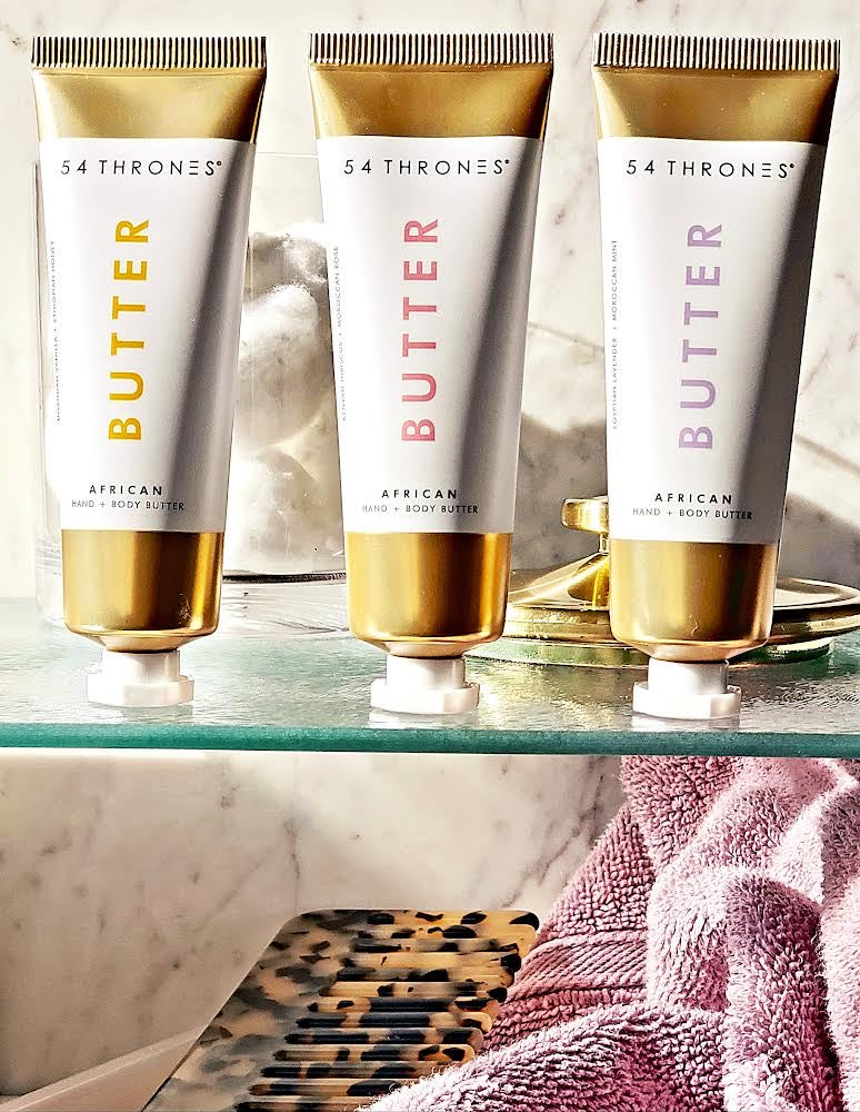 Three mini gold tubes of African hand + body butter on a bathroom shelf | 54 Thrones